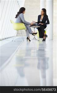 Two Businesswomen Meeting Around Table In Modern Office