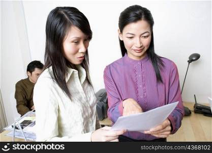 Two businesswomen reading a document