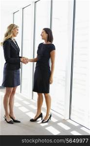 Two Businesswomen Shaking Hands In Office