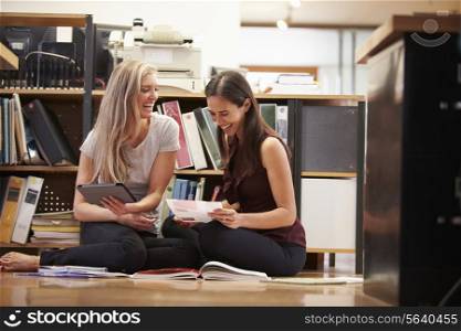 Two Businesswomen Sit On Office Floor With Digital Tablet