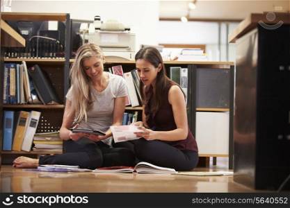 Two Businesswomen Sit On Office Floor With Digital Tablet