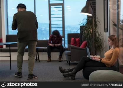 Two businesswomen sitting in a modern coworking space on a break from work and relaxing using a laptop. Selective focus. High-quality photo. Two business women sitingt in a modern coworking space on a break from work and relax using a laptop. Selective focus