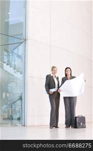 two businesswomen standing outside office building