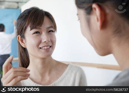 Two businesswomen talking and explaining project in the office