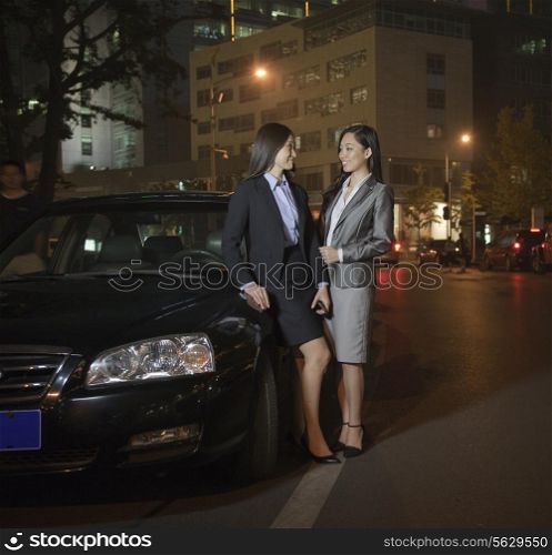 Two Businesswomen Talking By Car