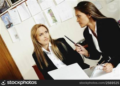 Two businesswomen talking to each other in an office