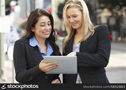 Two Businesswomen Using Digital Tablet Outside Office
