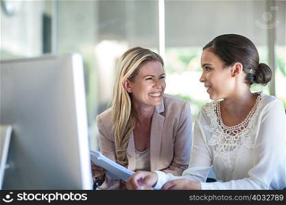 Two businesswomen working at office desk