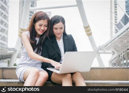 Two businesswomen working on laptop computer with happy funny emotion. Teamwork cooperation meeting of business office employee technology collaboration. Marketing and finance community interaction