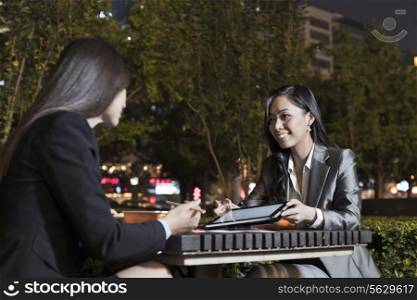 Two Businesswomen Working While Having Dinner