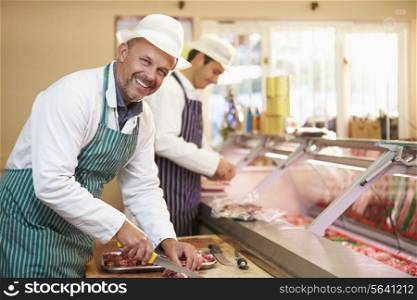 Two Butchers Preparing Meat In Shop
