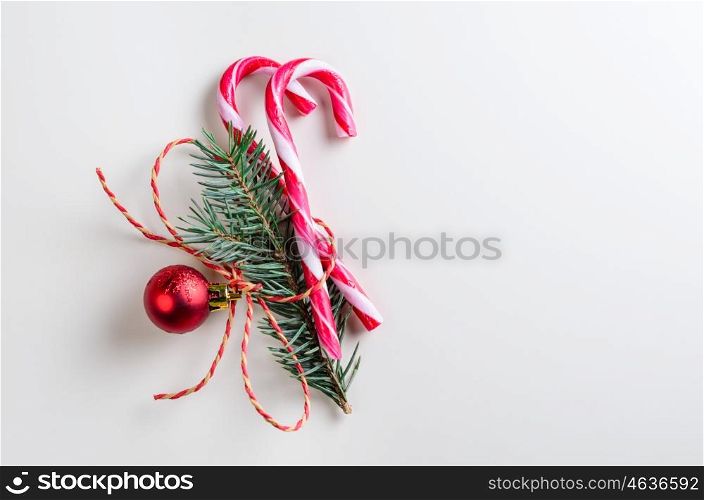 two candy cones with fir-tree branch. christmas or new year decoration of two candy cones with fir-tree branch and toy glass ball on gray background