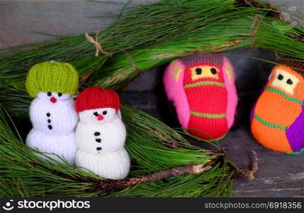 Two car transport pine tree for Xmas decoration, knitted colorful cars on wooden, two snowman standing beside make funny Christmas background