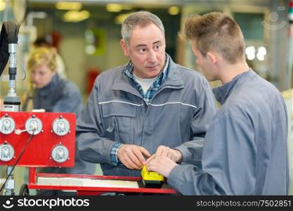 two careful workmen working at a factory