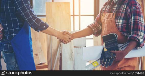 Two carpenters holding hands, The concept of working together until success