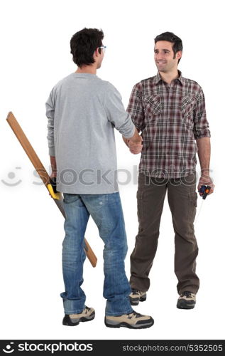 Two carpenters shaking hands