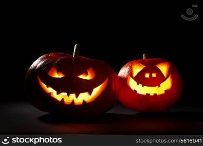 Two carved Halloween pumpkins jack-o-lantern on dark background