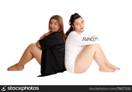 Two Caucasian and East India woman siting back to back on the floorin a white and black dress, isolated for white background.