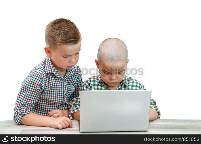 two Caucasian boys ,brothers on a white isolated background. one teaches the other to use a laptop.