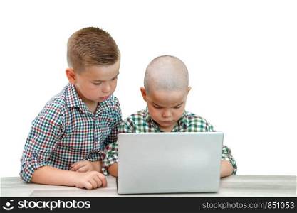 two Caucasian boys ,brothers on a white isolated background. one teaches the other to use a laptop.