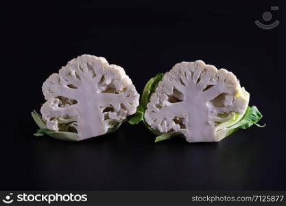 two cauliflowers, broccoli on a black background. two cauliflowers