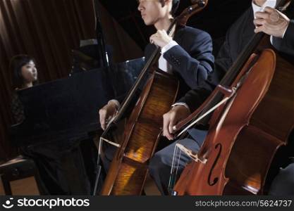 Two cellists playing the cello during a performance