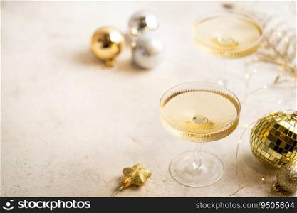 Two ch&agne glasses on gold shiny background with glitters and balls, top view. Two ch&agne glasses