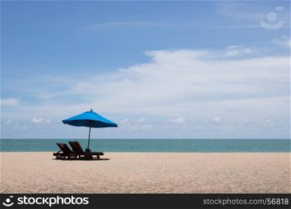 two chairs and blue umbrella on the beach
