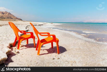 two chairs on beach of dead sea