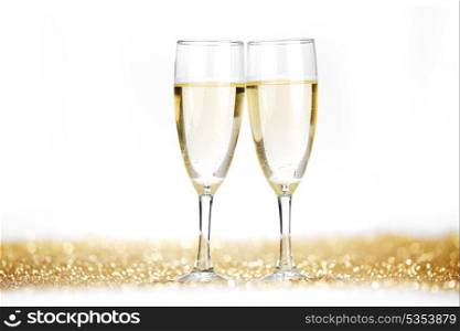 Two champagne flutes on gold shiny background