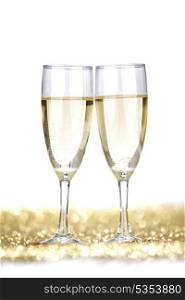Two champagne flutes on gold shiny background