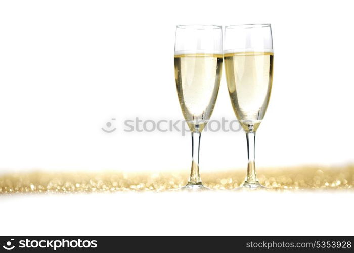 Two champagne flutes on gold shiny background