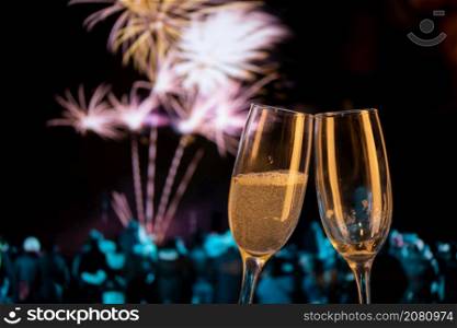 two champagne glasses against fireworks New Year&rsquo;s eve celebration