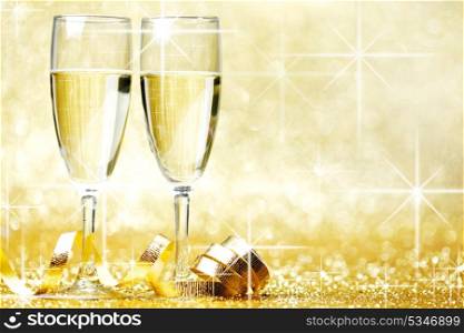 Two champagne glasses and decoration on golden background