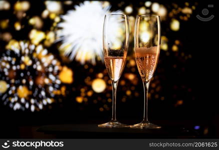 two champagne glasses and festive light happy New Year