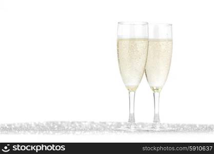 Two champagne glasses and silver shiny glitters isolated on white background
