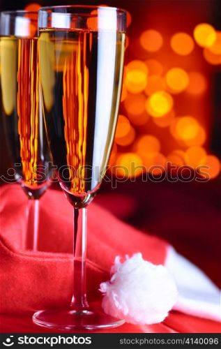 two champagne glasses on red silk with santa hat