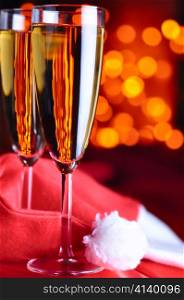 two champagne glasses on red silk with santa hat