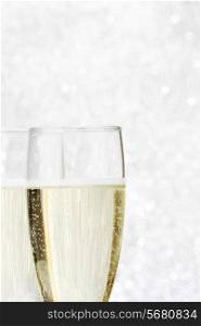 Two champagne glasses on silver bokeh background