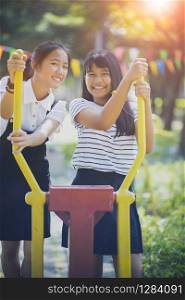 two cheerful asian teenager toothy smiling face in public playground