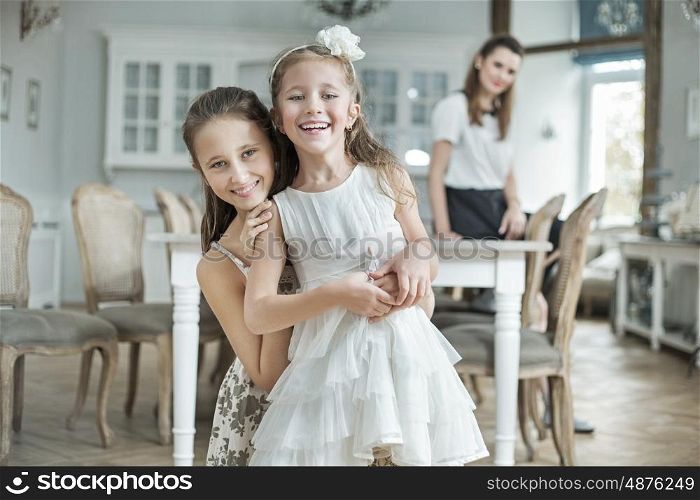 Two cheerful daughters posing with pretty mother
