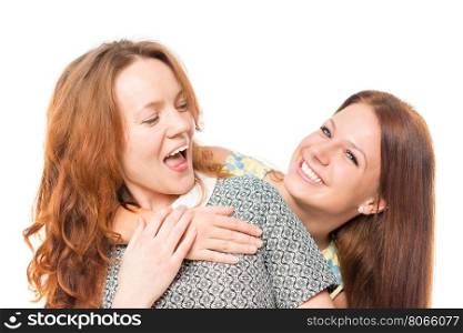 Two cheerful girlfriends embrace on a white background