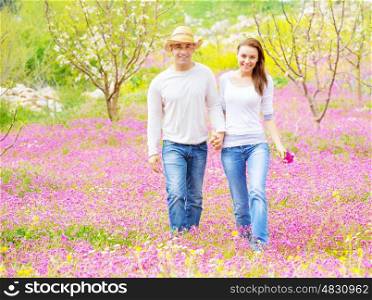 Two cheerful lovers walking in spring garden, having fun outdoors, relaxation on backyard, romance and love concept&#xA;