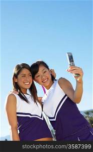 Two Cheerleaders Taking Photo of Themselves with Camera Phone