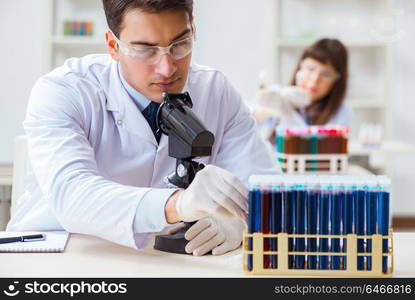 Two chemists working in lab experimenting