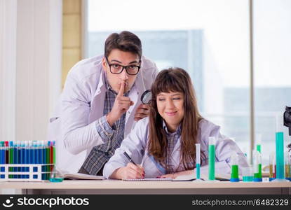 Two chemists working in lab experimenting