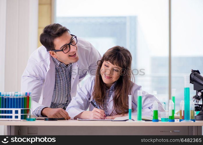 Two chemists working in lab experimenting