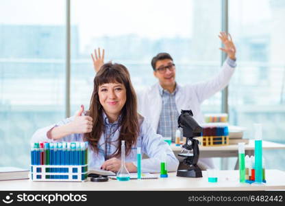 Two chemists working in lab experimenting