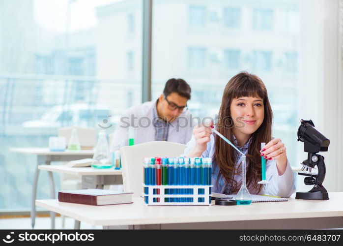 Two chemists working in lab experimenting