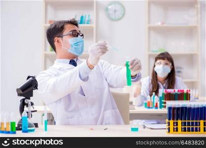 Two chemists working in lab experimenting